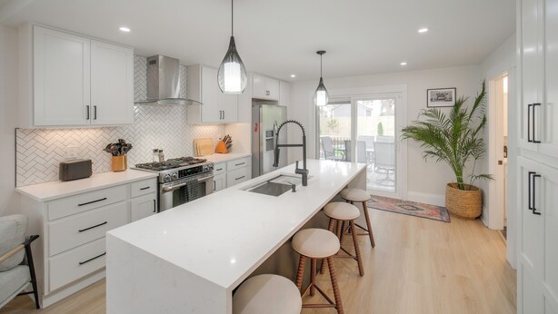 A modern kitchen with white cabinetry, a central island with stools, a stainless steel range, and a herringbone backsplash. - Tremont Retreat w/ Putting Green Near Downtown (Cleveland)