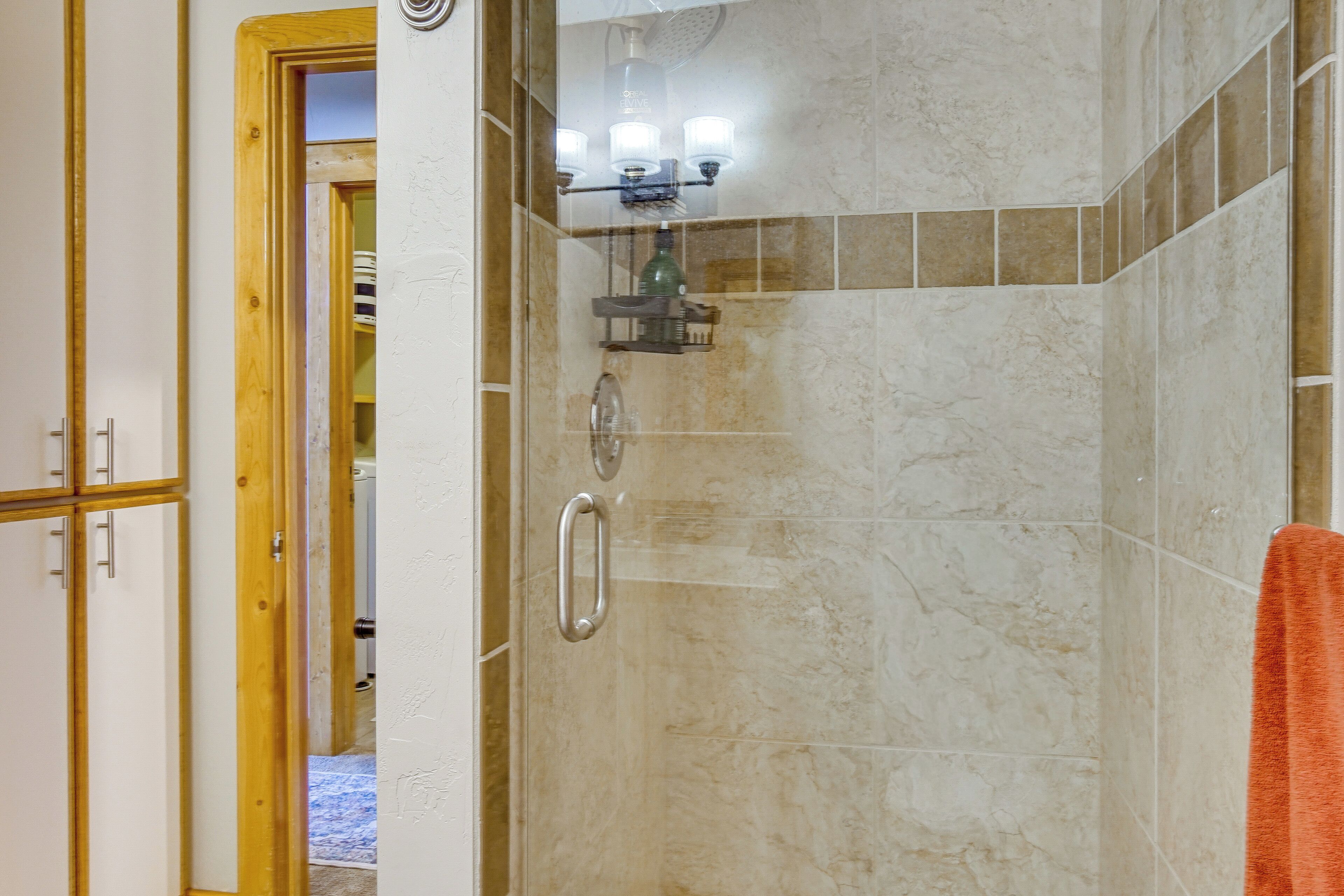 A bathroom with a shower, a towel rack, and a mirror.