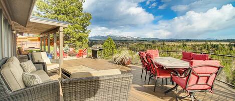 A covered outdoor deck with wicker furniture, a table, and chairs.