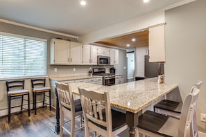 A kitchen with white cabinets, a granite countertop, and a central island with seating. - Colorado Countryside Living 7 Mi to Chatfield Res! (Louviers)