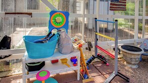 Ein Spielbereich mit Basketballkorb, blauem Eimer, Spieltrommeln und einer kleinen Bällecke.