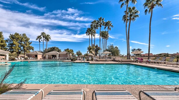 A swimming pool with lounge chairs and palm trees. - Patio & Grill! Resort-style Sun Lakes Escape (Chandler)