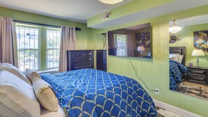 A bedroom with a bed, a chandelier, a dresser, a mirror, and a window with curtains. - Walkable Extended Base 2 Mi to Dtwn & Penn Station (Newark)