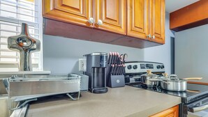 A kitchen with wooden cabinets, a coffee maker, a toaster, and a stove. - Walkable Extended Base 2 Mi to Dtwn & Penn Station (Newark)