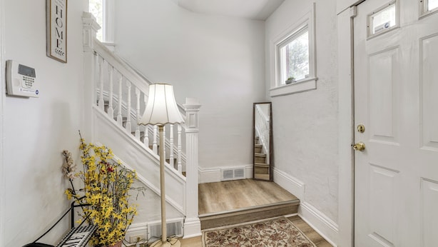 A staircase with a white railing, a lamp, a mirror, and a door. - Stroll to Falls & Seneca Casino! Family Getaway (Niagara Falls)