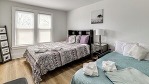 A bedroom with a bed, bedside table, lamp, and a picture on the wall. - Stroll to Falls & Seneca Casino! Family Getaway (Niagara Falls)