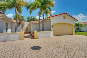 A residential property with a paved driveway, a garage, and palm trees. - Pool Access & Lake-view Lanai! Port Charlotte Gem (Port Charlotte)