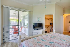 A bedroom with a bed, a TV, a drying rack, and a closet. - Pool Access & Lake-view Lanai! Port Charlotte Gem (Port Charlotte)