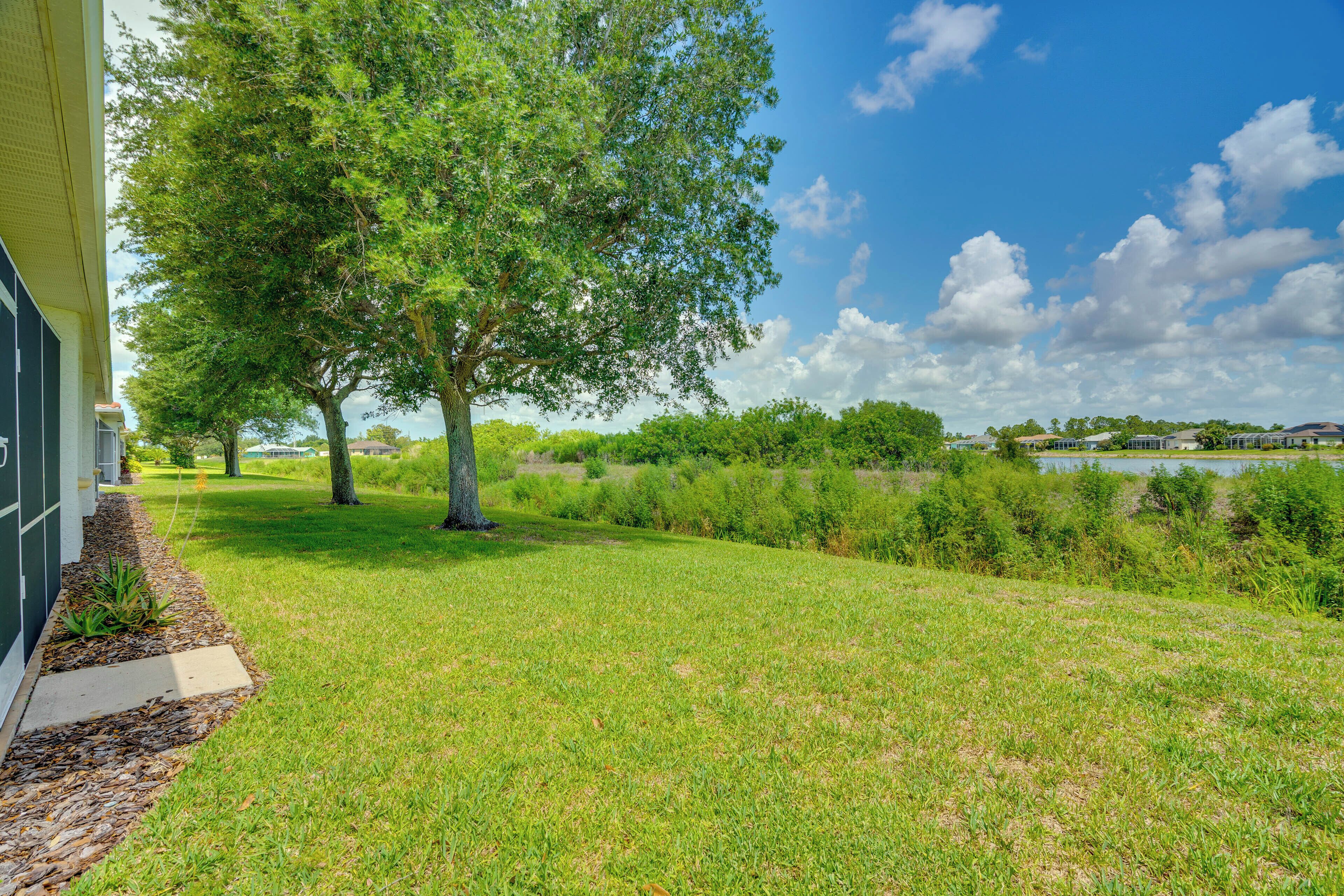 A grassy area with trees and a building.