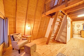 A wooden interior with a staircase, a chair, a table, and a clock on the wall. - 4-cabin Haven Near Kenai River: Catch & Freeze! (Sterling)