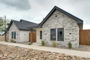 A modern two-story house with a stone facade, a wooden fence, and a well-maintained front yard. - 7 Mi to Goodfellow Afb: Home w/ Fenced Yard (San Angelo)