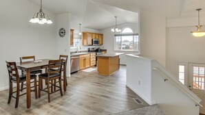 A modern kitchen with wooden cabinets, a dining table, and chairs. - 4 Mi to Ellsworth Afb! Suburban Home for Families (Box Elder)