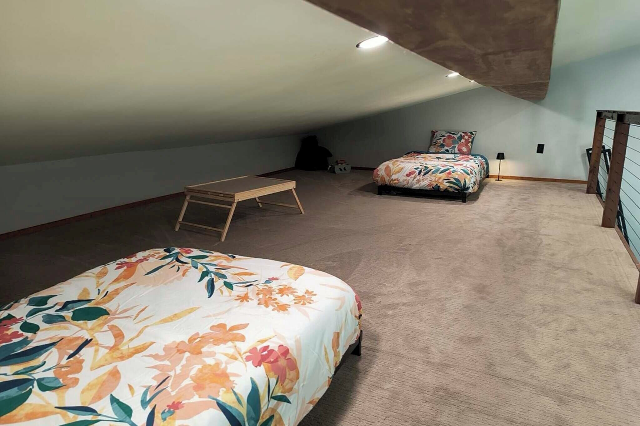 A bedroom with a bed, a small table, and a bunk bed.
