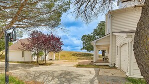 A residential driveway with a garage, a tree, and a house with a porch. - Hiking, Wineries & More! Mtn-view Gem in Tehachapi (Tehachapi)