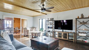 A spacious living room with a large television, wooden ceiling, and a cozy seating area. - Hiking, Wineries & More! Mtn-view Gem in Tehachapi (Tehachapi)