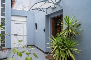 A blue exterior wall, a white door, a window, and a potted plant. - Rustic Village Studio by the Tagus - Porto Brandão (Caparica)