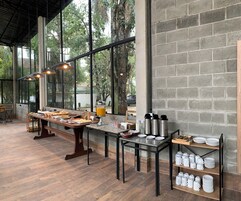 Un bufé de desayuno con diversas opciones de comida, termos y un dispensador de jugo.