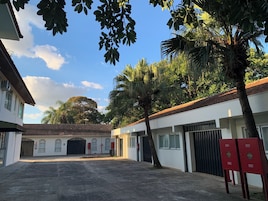 Un patio con un edificio, palmeras y cielo despejado.