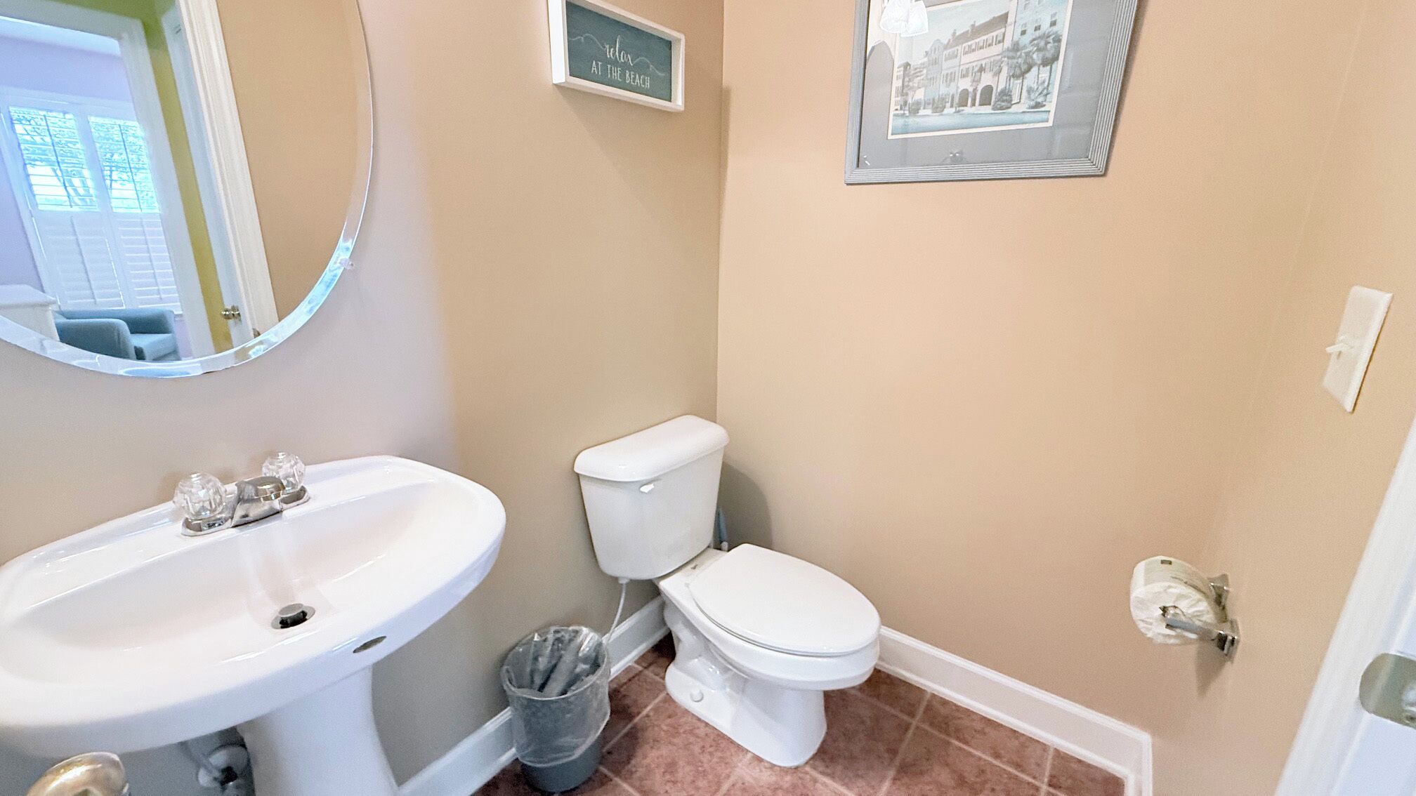 Een badkamer met een wastafel, toilet en een fotokader aan de muur.