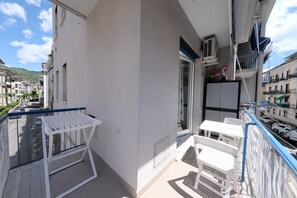 A balcony with a table and chairs, a window, and a door. - Seaside Apartment - Sleeps 6 - Balcony (Rapallo)