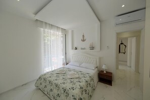 A bedroom with a bed, a nightstand, a mirror, and a door. - Seaside Apartment - Sleeps 6 - Balcony (Rapallo)