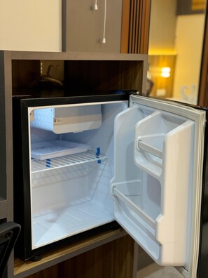 Un refrigerador abierto con estantes y un compartimento congelador.
