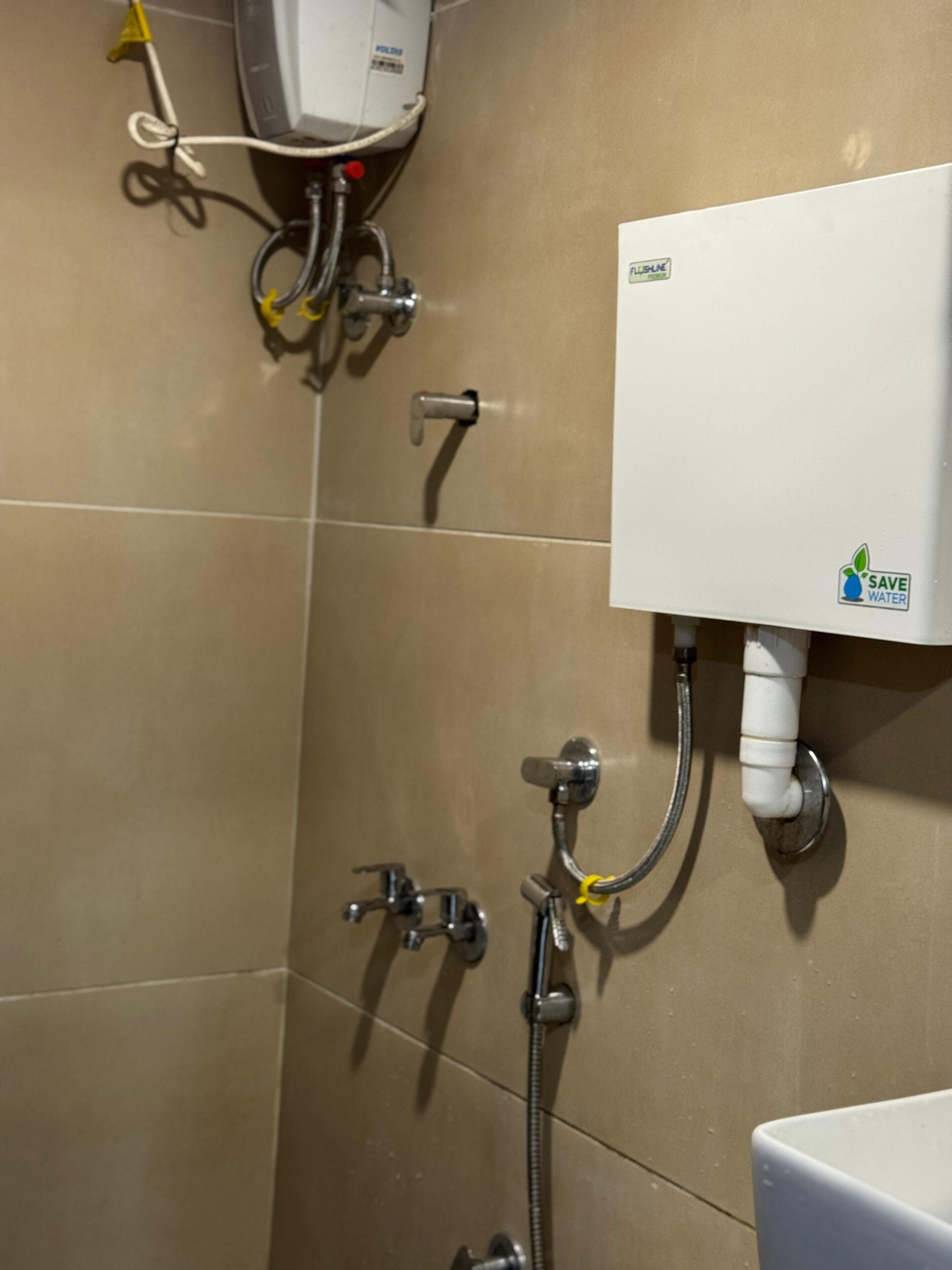 Un baño con inodoro, ducha y calentador de agua.