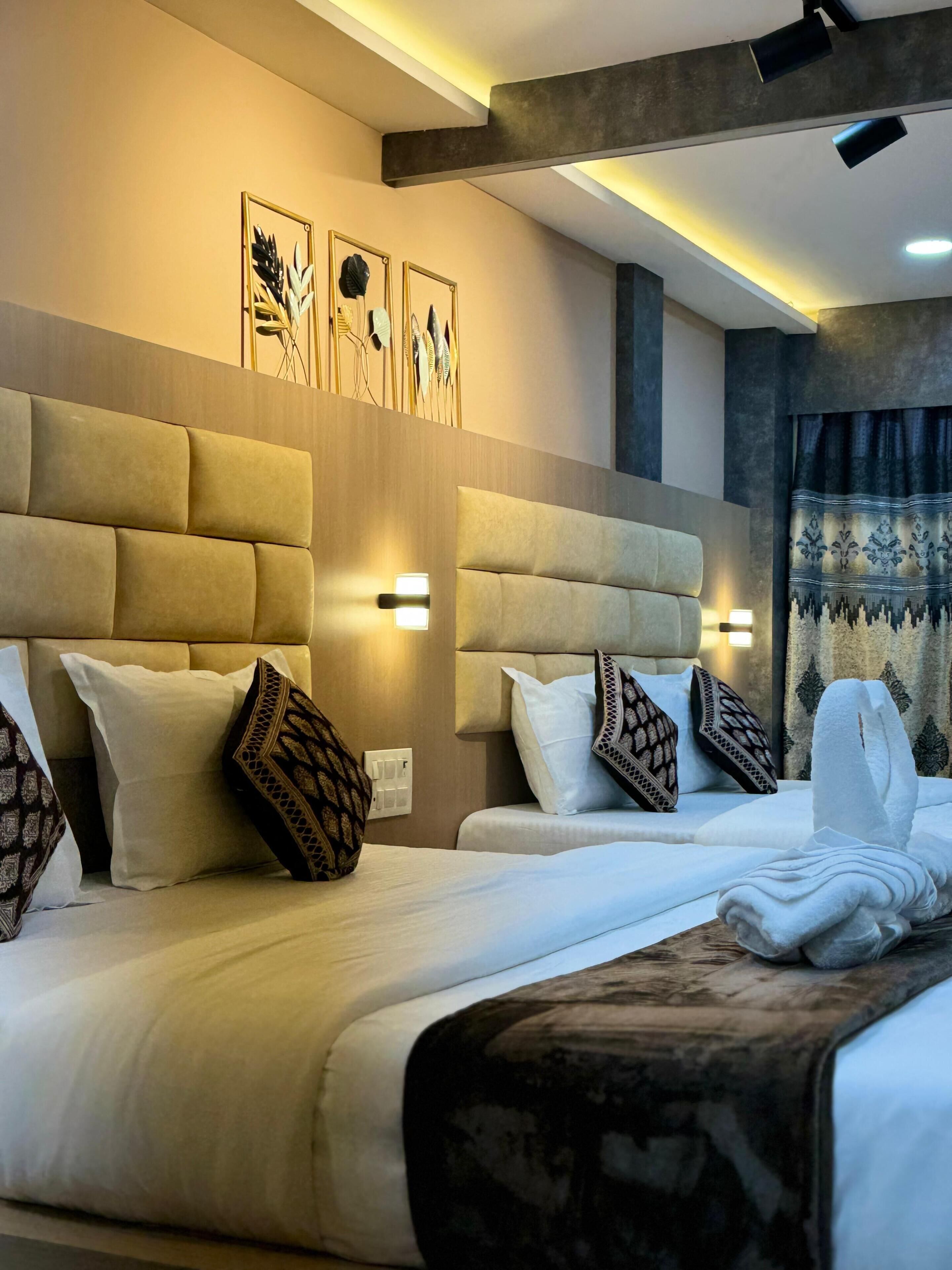 A hotel room with two beds, headboards, wall-mounted lights, and a decorative wall panel.