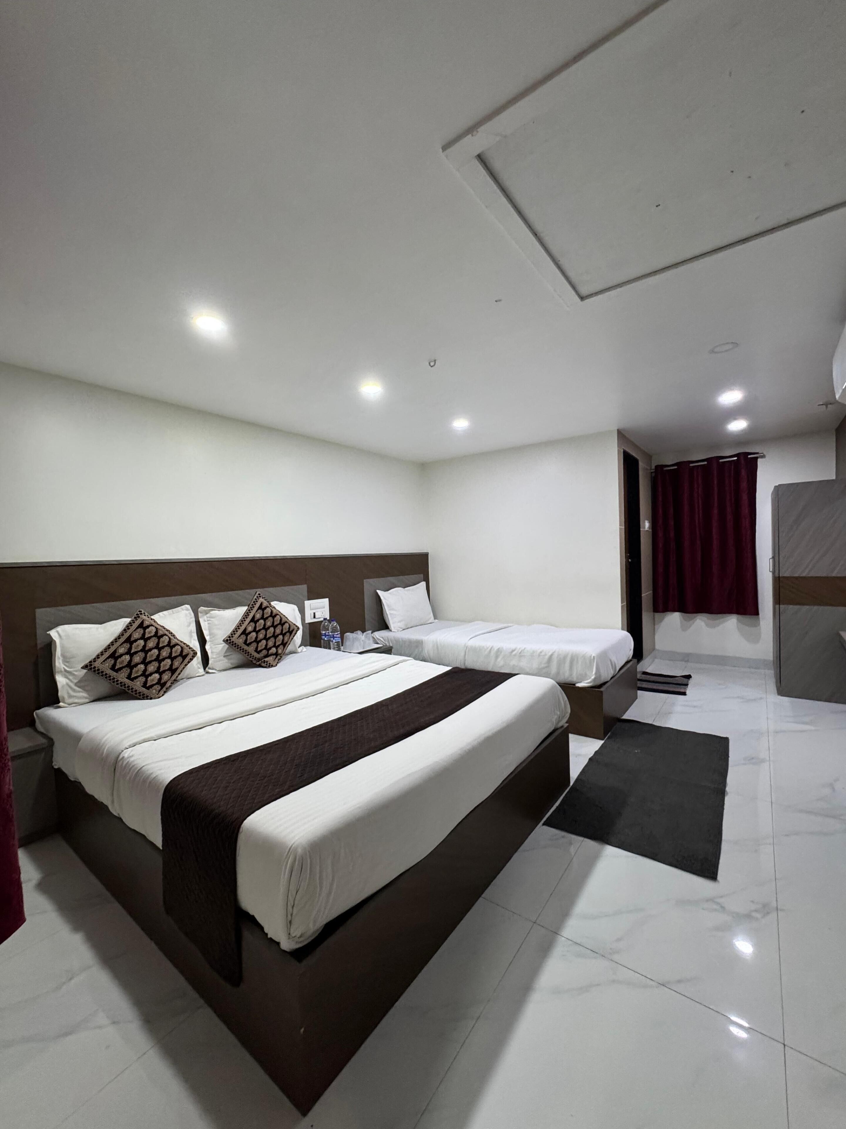 Une chambre d’hôtel moderne avec deux lits, une grande fenêtre et une salle de bain avec douche.