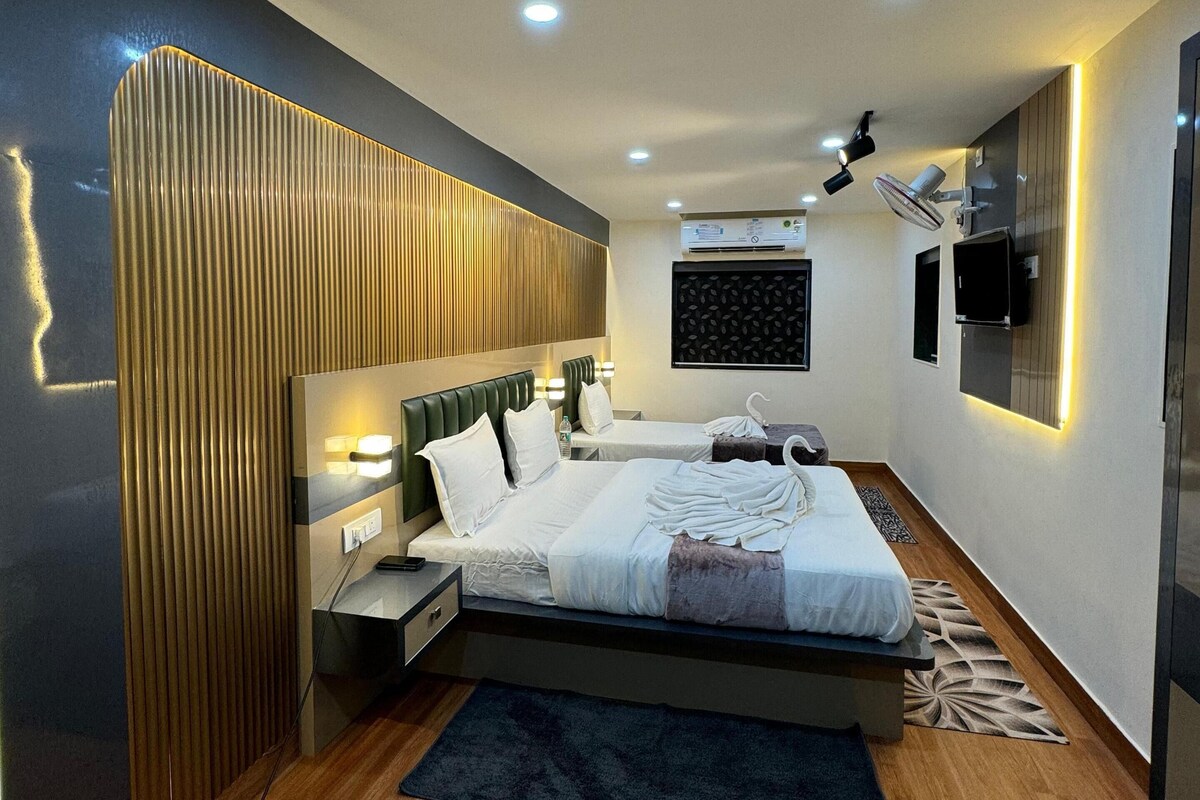 Un dormitorio moderno con cama, mesitas de noche, televisor montado en la pared y luces empotradas en el techo.