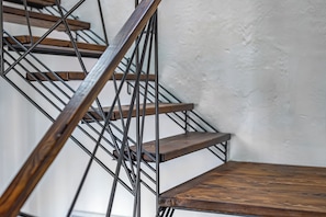 Una escalera con escalones de madera y barandillas de metal.