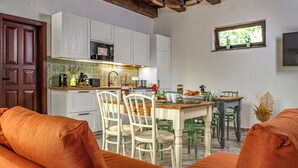 A kitchen with white cabinets, a dining table with chairs, and a chandelier.