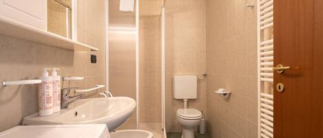 A bathroom with a sink, toilet, and shower.