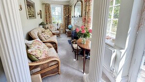 Quarto com móveis de vime, um globo e um vaso de flores.