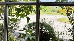 A window with a view of a garden and a pathway. - The Chapel Room at Sandhill House (Gunnislake)