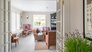 A spacious living room with a sofa, armchairs, a coffee table, and a bookshelf. - Shammer Lodge, North Creake, Norfolk (North Creake)
