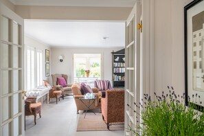 A spacious living room with a sofa, armchairs, a coffee table, and a bookshelf. - Shammer Lodge, North Creake, Norfolk (North Creake)
