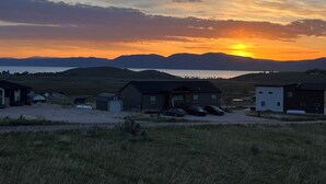 Un quartier résidentiel avec des maisons, un plan d’eau et des montagnes en arrière-plan.