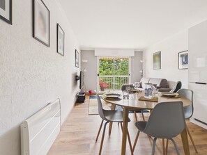 A modern kitchen with a dining table, chairs, and a view of the outdoors. - 300m from beach, balcony, parking, flat for 3 (Pornichet)