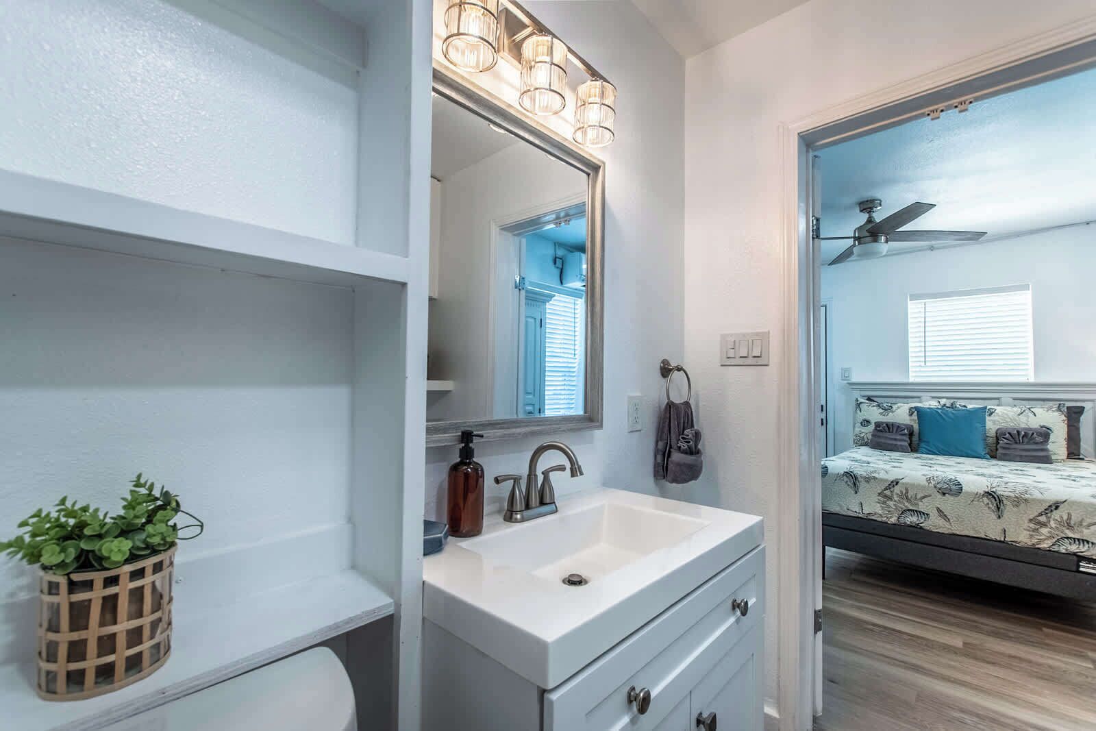A bathroom with a white sink, a mirror, and a ceiling fan.