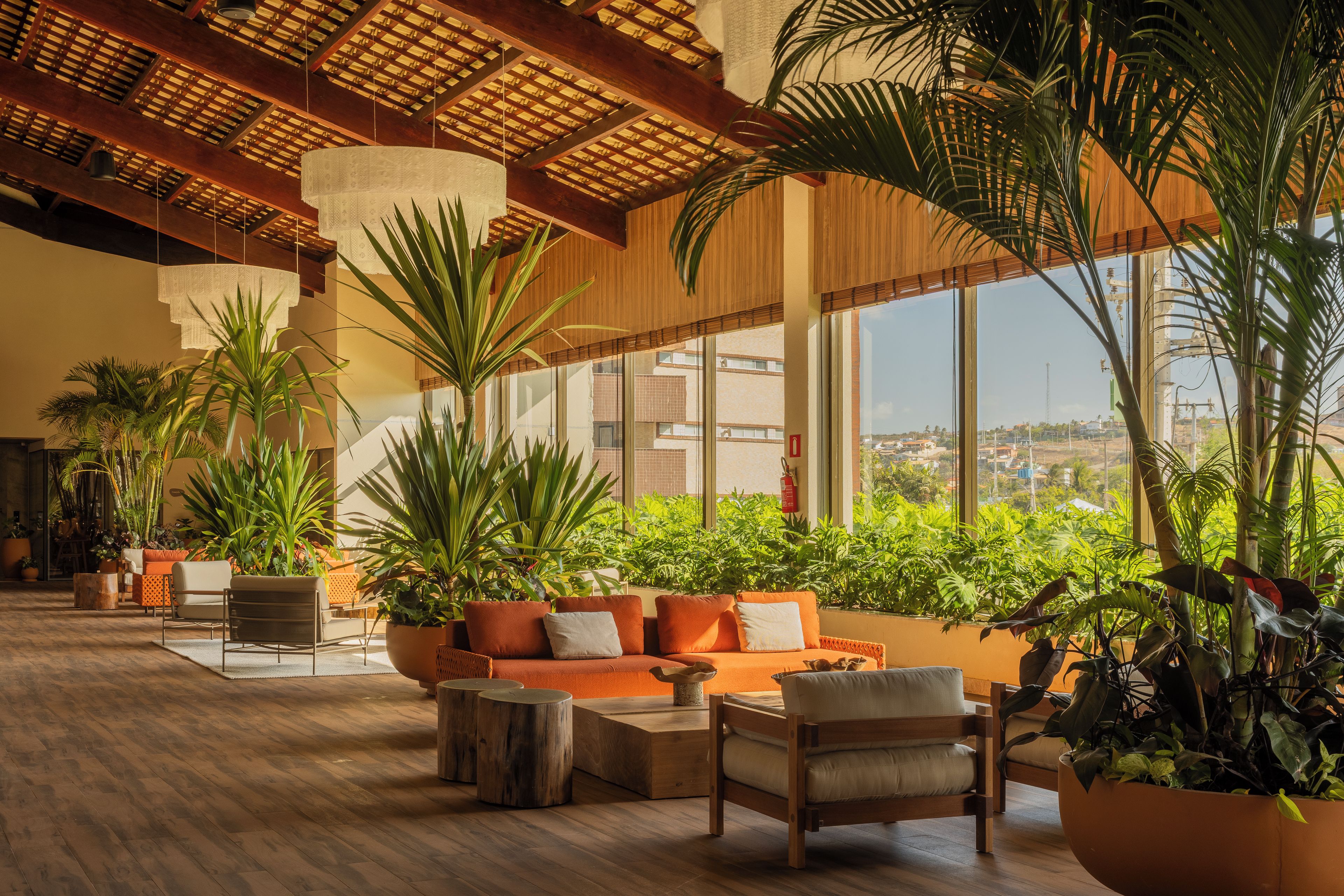 A spacious indoor area with a wooden floor, a sofa set, and large windows offering a view of the cityscape.