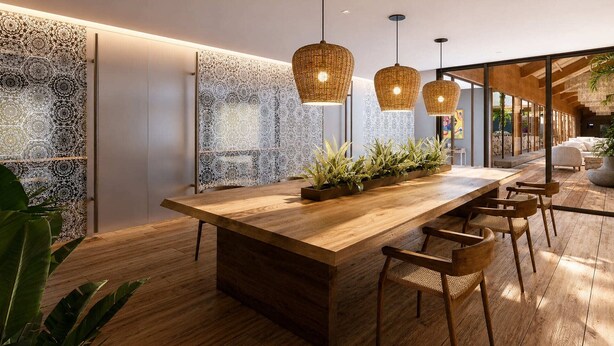 Una cocina moderna con una isla de madera, luces colgantes y un detalle decorativo en la pared.
