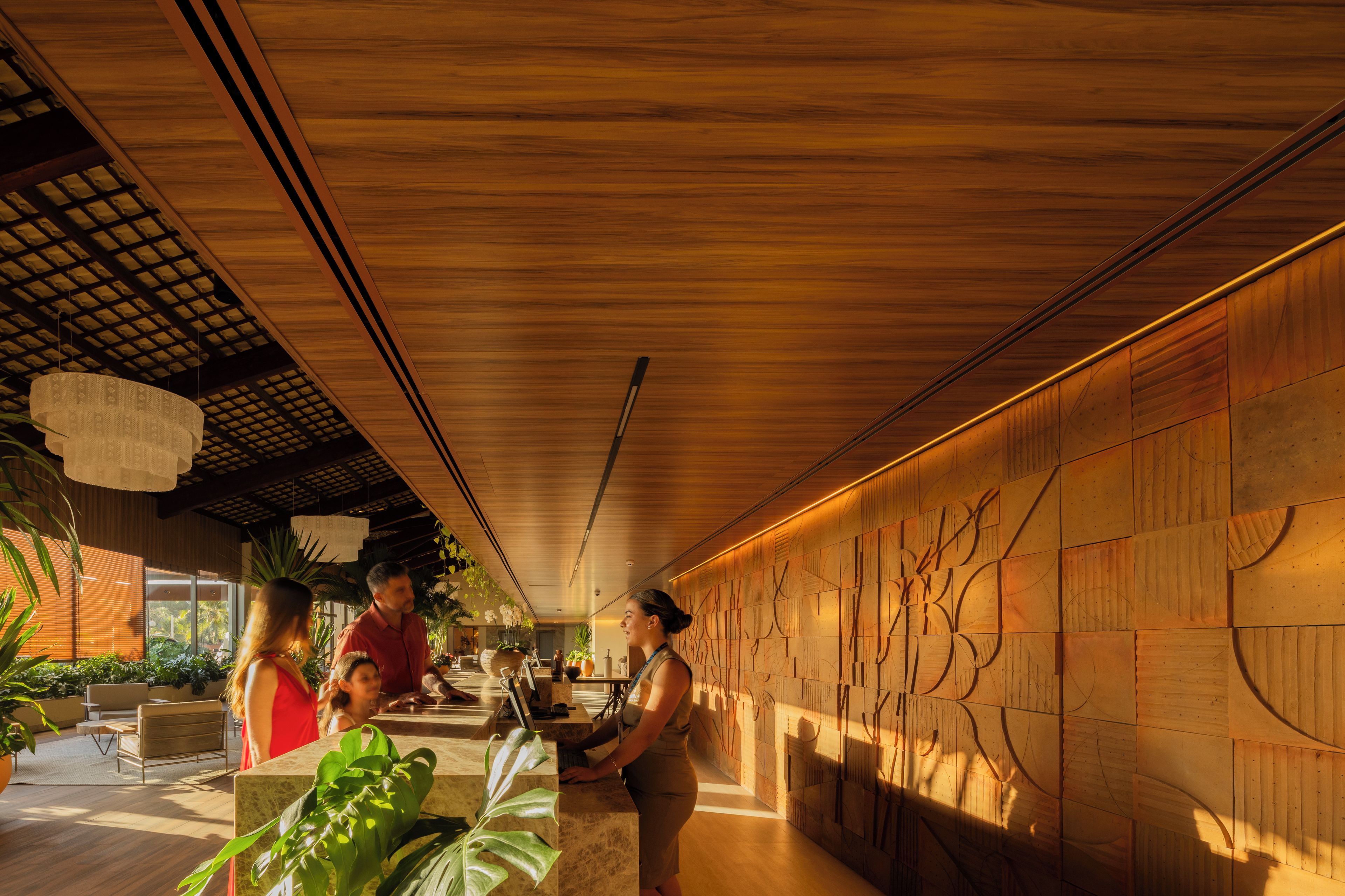 A reception area with a wooden ceiling, a reception desk, and a wall with geometric patterns.