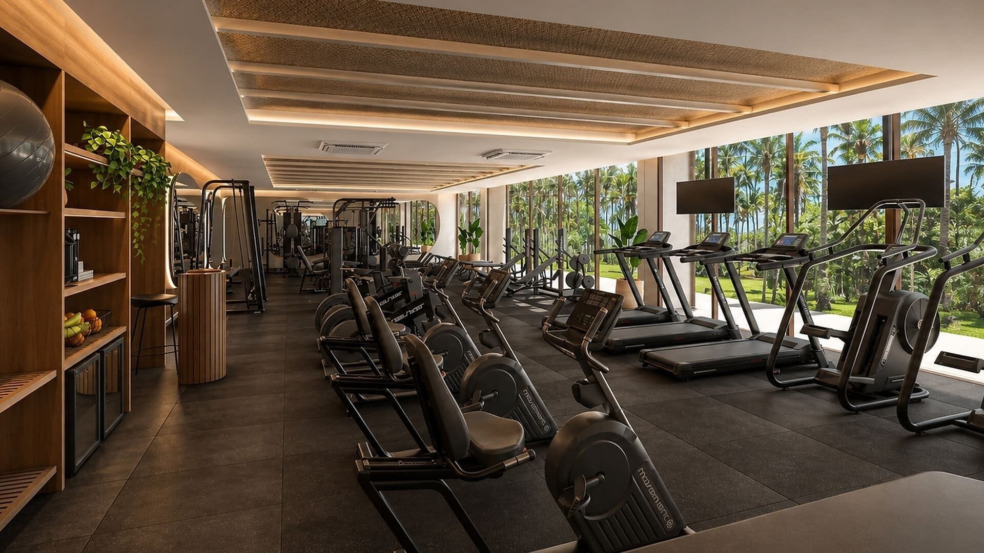 Un gimnasio con cintas de correr, máquinas de pesas y un amplio ventanal con vistas a palmeras.