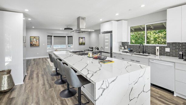 A modern kitchen with a marble island, bar stools, and a large window. - New Listing--A Woodland Escape--Call for Monthly Rates (Cambria)
