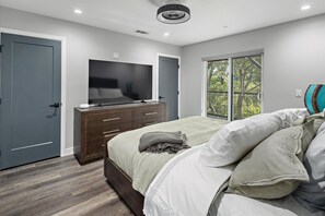 A bedroom with a bed, a TV, a dresser, and a window with a view. - New Listing--A Woodland Escape--Call for Monthly Rates (Cambria)