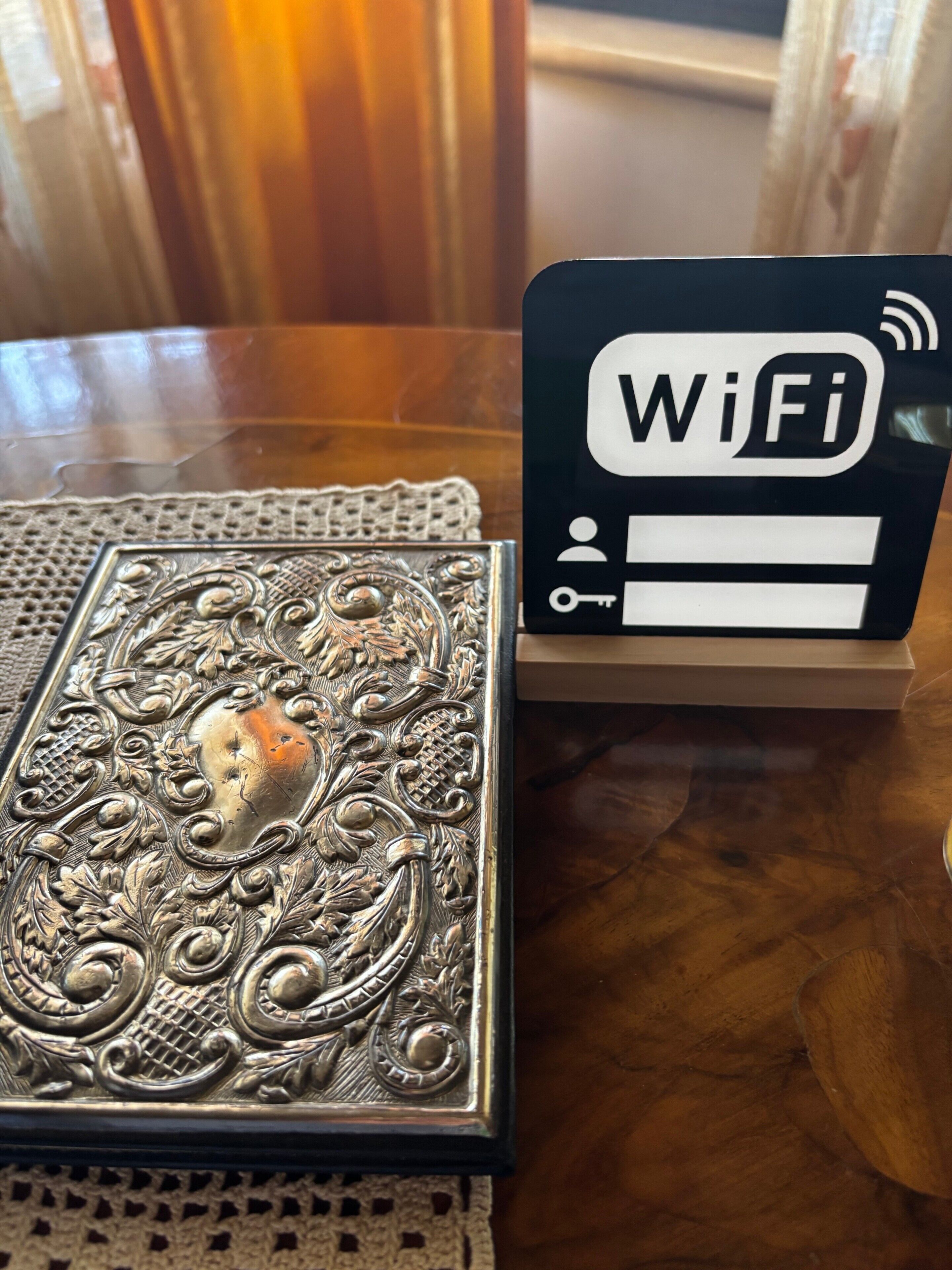 Ein Tisch mit einem dekorativen Metallgegenstand und einem schwarzen Schild mit 'WiFi' und Symbolen.
