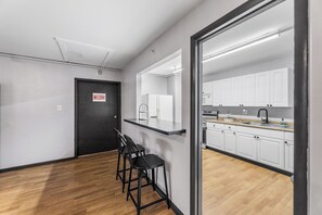 Eine moderne Küche mit weißen Schränken, einer schwarzen Arbeitsplatte und Holzboden.