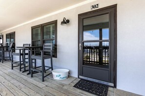 A building with a door marked '302,' a porch with outdoor seating, and a bucket labeled 'FLIP FLOPS.' - OE302- Hidden Jewel! Walk To Festivals, Beach, Restaurants, All! Nice Pool! (Gulf Shores)