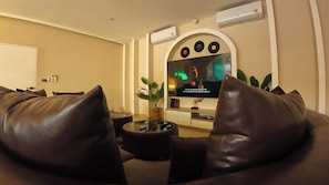Ein modernes Wohnzimmer mit einer Couch, einem Couchtisch und einem Fernseher.